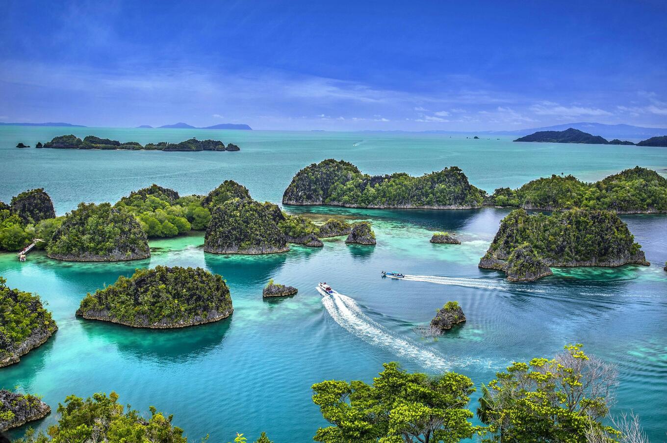 Aerial view of Raja Ampat's emerald islands and turquoise lagoons, Indonesia.